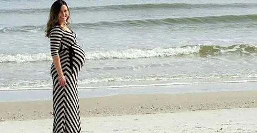 Expectant Father Captures Stunning Dolphin in Background of Wife's Pregnancy Photo